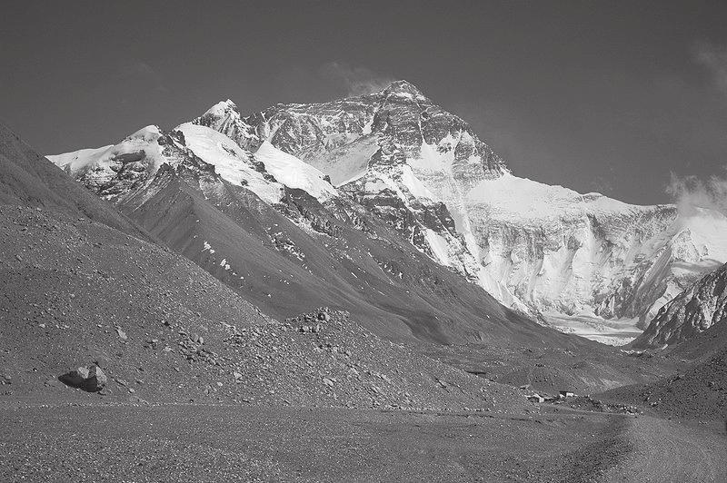 Ancillary Material Image 3 Mount Everest Picture Description: This is a photo of Mount Everest. In the foreground of the photo the ground looks like it is covered with gravel.