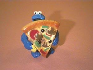 Cookie Monster finishes the first slice of pizza and gets started on the second one.