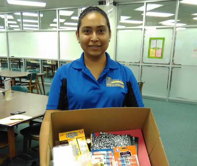 Student worker holds school supplies that was delivered to a local school district.