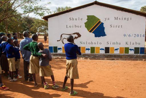 Caption: Students enjoy the view of their newly-painted school wall at Loibor Siret