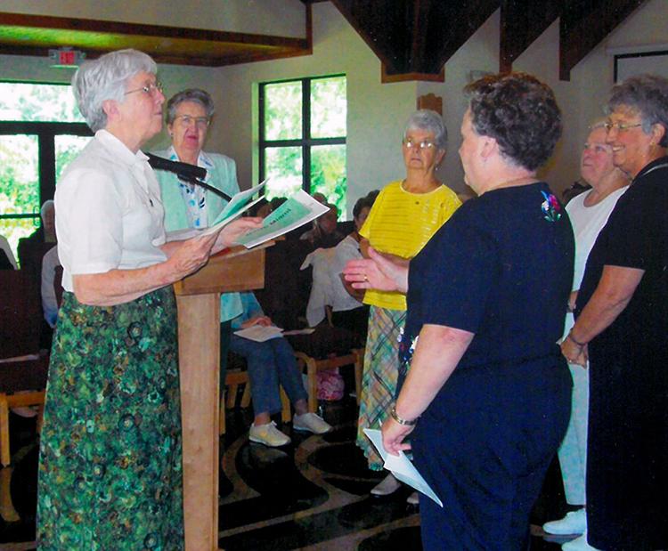 Left: Sister Anne Liam Lees, left, distributes assignments to