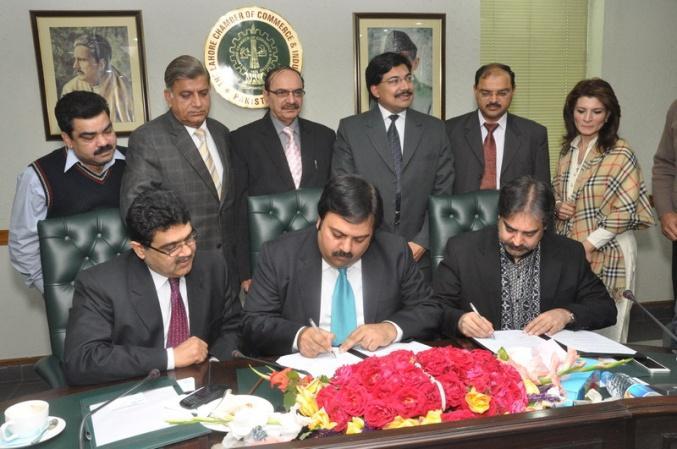 Zia Amin Sheikh, President, SCCI are signing MoU while officals and members of both the organizations are also seen.