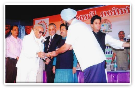 Sh. Baldev Raj Kamrah receiving Life Time Achievement Award from Raja Randhir Singh (Secretary General / IOA) along with H.H. Jyotiraditya M. Scindia (Chairman), Sh. Rajiv Shukla (M.P.