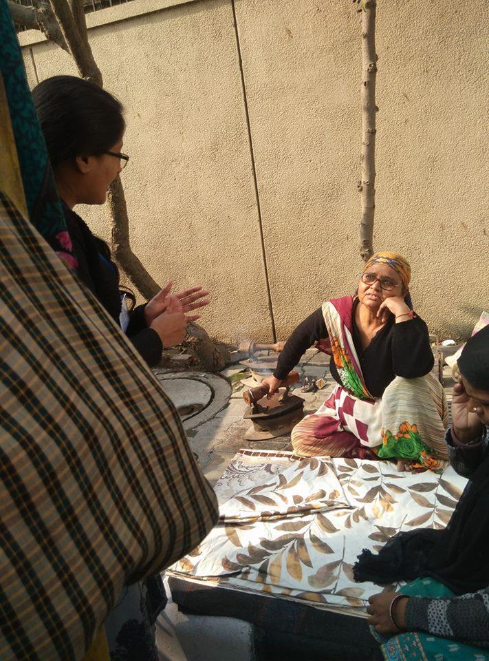 Photo: A volunteer teaching a lady about payment methods.