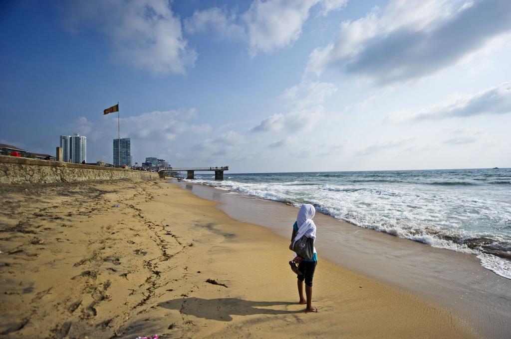 ABOVE: A muslim woman looks out to sea a little down the coast from central Colombo.