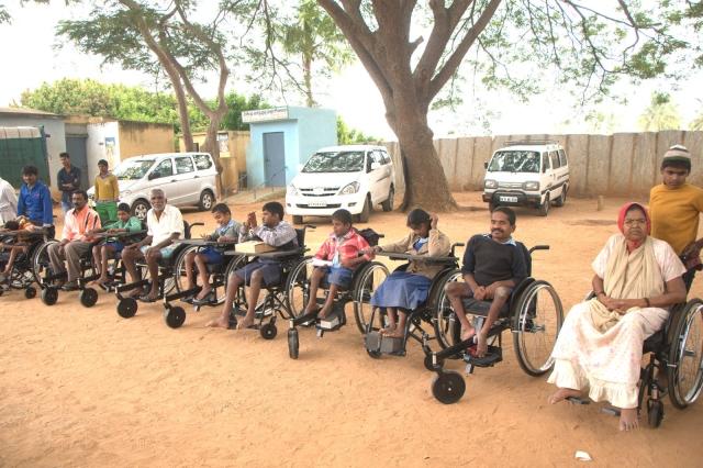 WHEELS CHAIRS TO PHYSICALLY CHALLENGED Photographs showing Distibution of wheel chairs by Vasavi Club in association