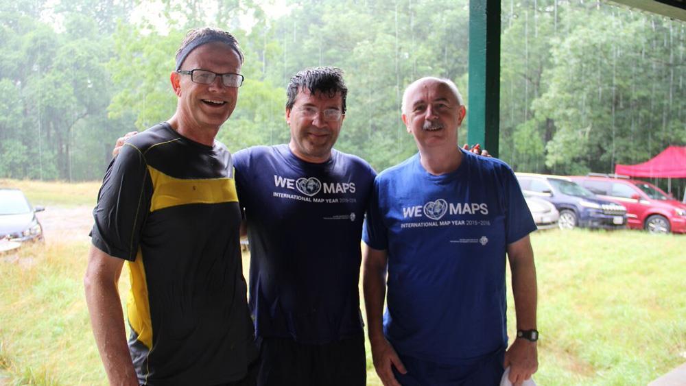 Heavy rains and flooding challenged orienteering event participants but did little to dampen the spirits of (from left to right) ICA president Kraak, ICA past president Georg Gartner, and ICA