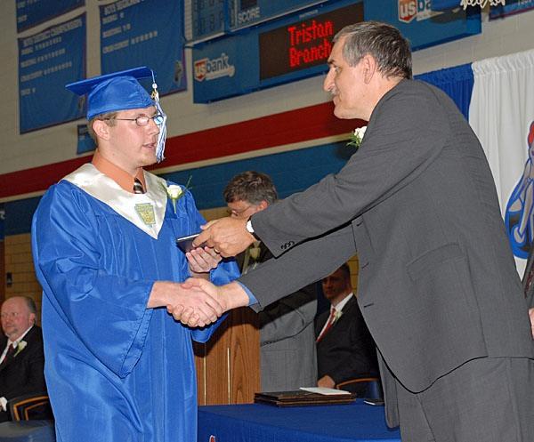 Trevor Wells receives his diploma from Crestview Board of Education Vice President Lonnie Nedderman during 2011 graduation