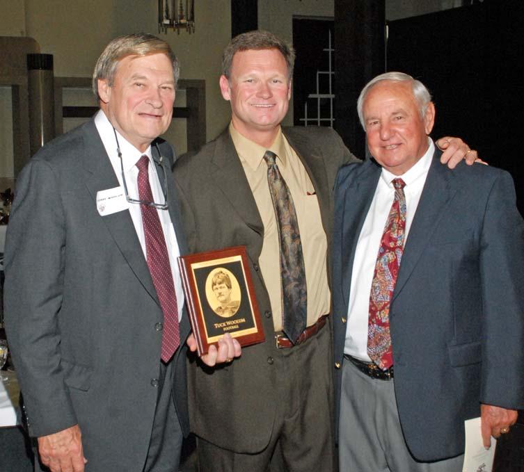 He is flanked in this photo by his father, Jerry Woolum (left), and by former EKU Football Coach Roy Kidd (right).