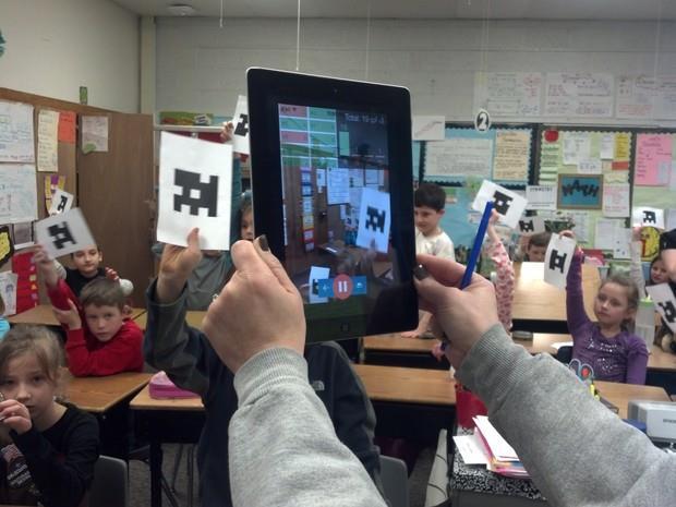 The teacher uses the ios or Android app on their smartphone or tablet to slowly scan the room.