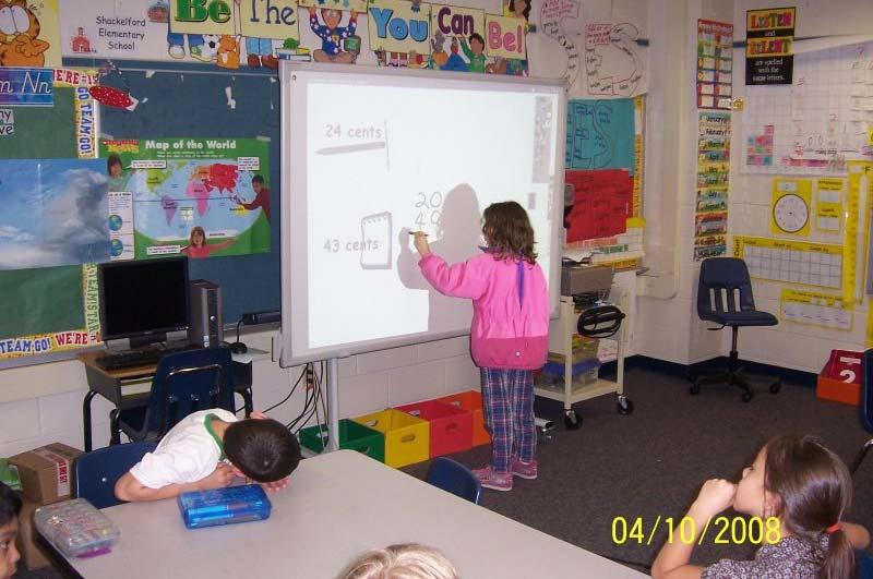 Shackelford Elementary School second-grade teacher Angie Hill and her students use an interactive Promethean Active Board to complete their work on a daily