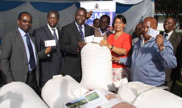 Prof. Agnes Mwang ombe, Principal, CAVS hands over bean seed varieties to representatives of Kenya Seed Company.